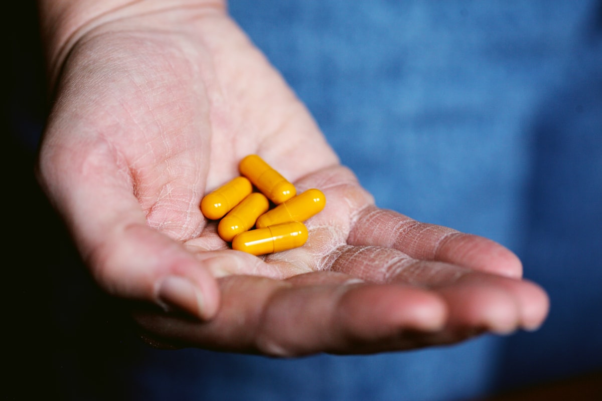 Natural joint support supplements on a wooden surface surrounded by herbs